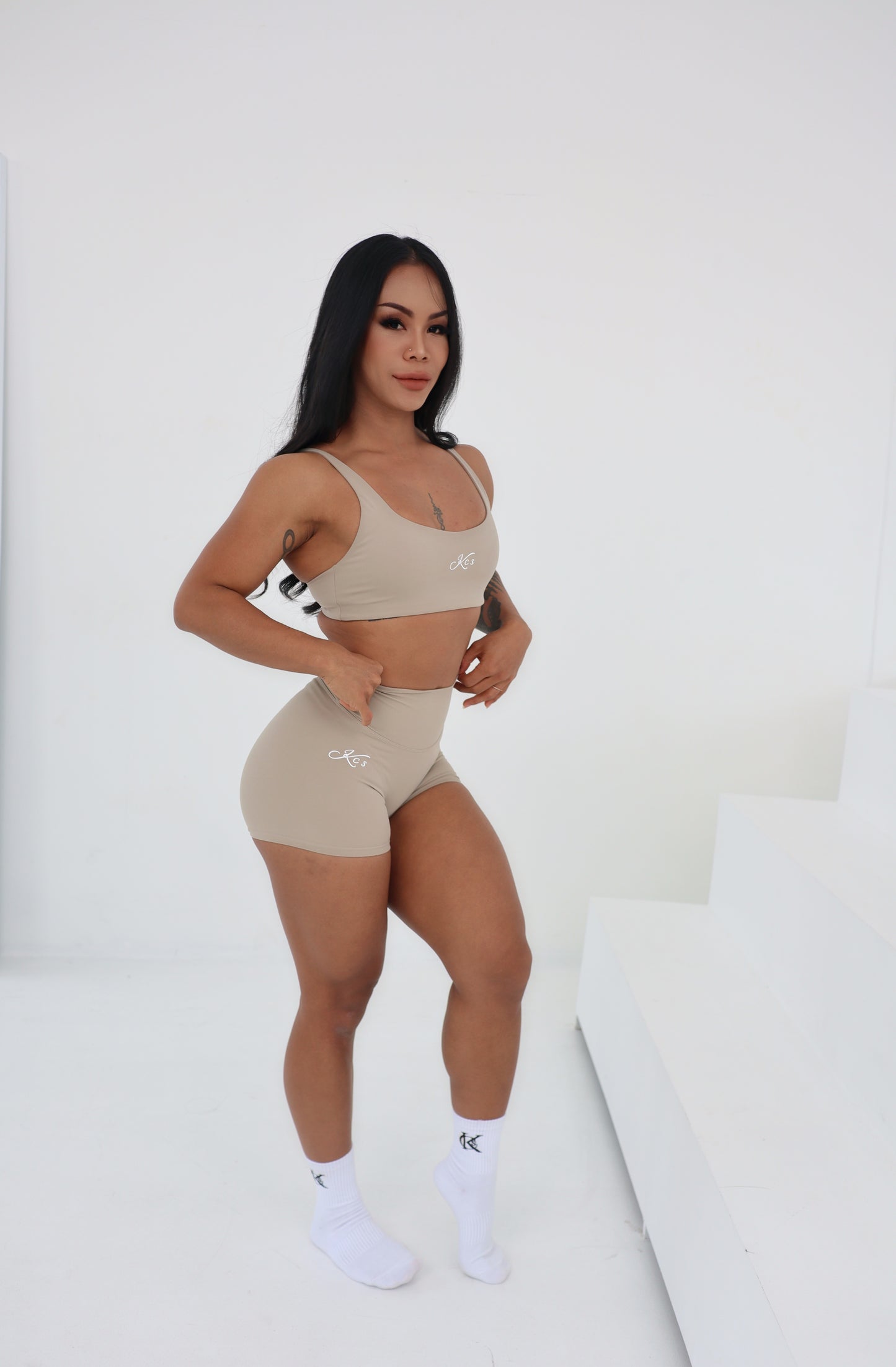 “Model wearing Signature Bra and High-Waisted Shorts in beige , size M– light-to-medium support and curve-enhancing fit”